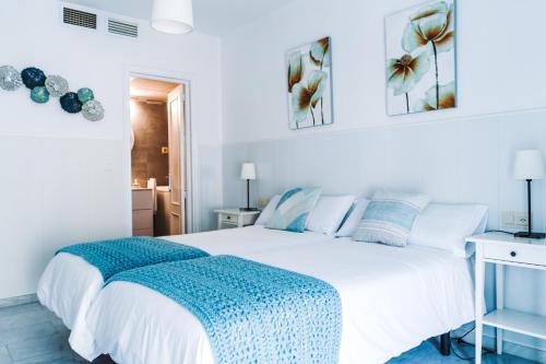 隆达Apartamento Victoria con parking incluido的卧室配有白色的床和蓝色毯子