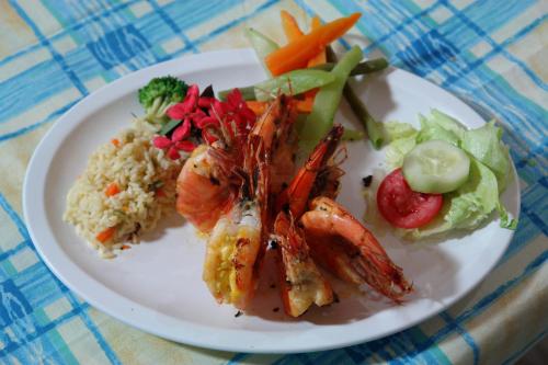 埃尔库科米拉弗洛雷斯酒店的含有虾米和蔬菜的白盘食物