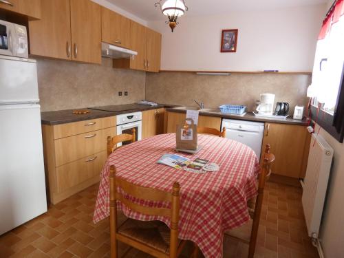 塞拉克安布赫特公寓的厨房配有一张带红白桌布的桌子