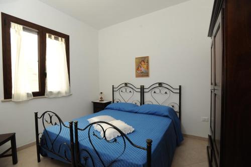 佩斯科勒海滨Carmelina的一间卧室设有蓝色的床和窗户。