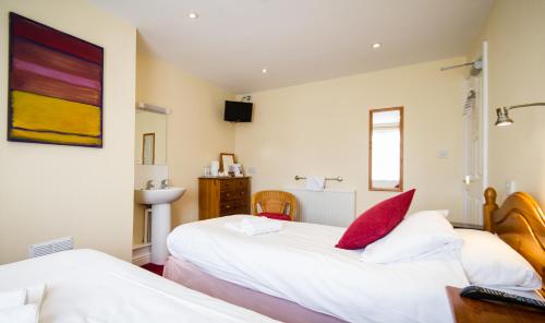 赫里福德基德威尔小屋旅馆的一间卧室设有两张床和盥洗盆