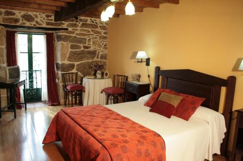 Rairiz de Veiga卡萨瑞克托拉康达旅馆的一间卧室配有一张床和一张桌子及椅子