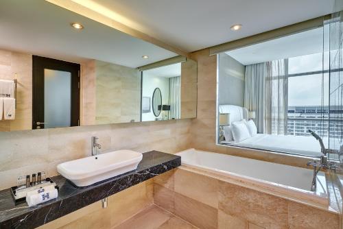 马六甲惠勝酒店的带浴缸、水槽和镜子的浴室