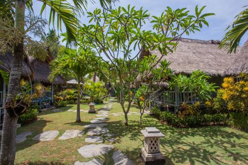 蓝梦岛TS蓝梦小屋旅馆的一座花园,位于一个种有树木和岩石的度假胜地