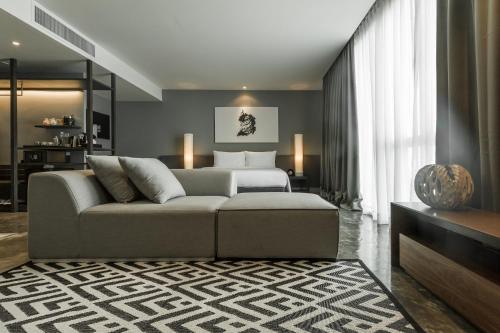曼谷爵世曼谷酒店的客厅配有沙发和1张床