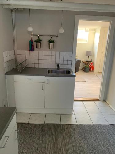 维泽桑讷Surf Apartment Stormgade的厨房配有白色橱柜和水槽