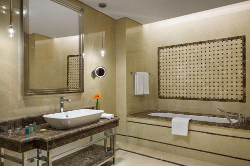 哈伊勒哈伊勒千禧国际酒店的浴室配有盥洗盆和浴缸。