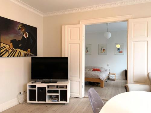 哥本哈根ApartmentInCopenhagen Apartment 1436的客厅配有台面上的平面电视