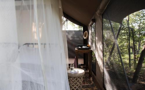 提姆巴瓦提禁猎区Simbavati Trails Camp的一间带窗帘的卧室和一个带水槽的帐篷