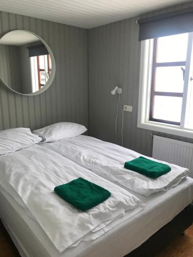 埃基斯蒂尔索尔巴基度假屋的一张白色的床,上面有两条绿色毛巾