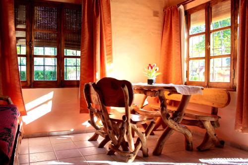 圣拉斐尔卡瓦尼亚斯卡尔德龙二号山林小屋的一间带桌椅和窗户的用餐室