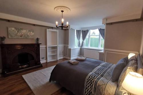 格拉斯哥Broomfield Cottage South Luss的一间卧室设有一张大床和一个壁炉
