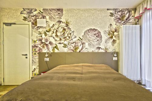 罗卡皮耶托雷Hotel Venezia的一间卧室配有一张带花卉壁纸的床