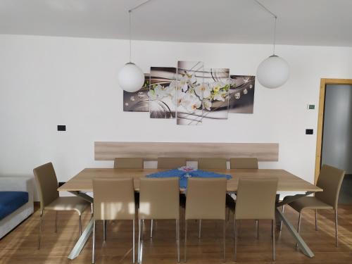 帕苏德尔托纳莱Appartamento DIAMANTE的一间带木桌和椅子的用餐室