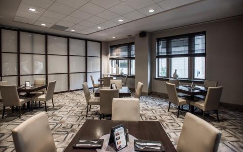 达拉斯达拉斯市中心白玉兰大酒店的用餐室设有桌椅和窗户。