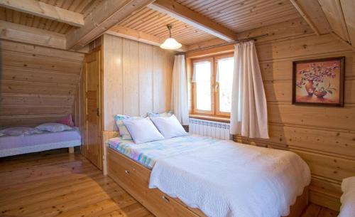 考斯赛力克Pokoje u Uli的木制客房内的一间卧室,配有一张床