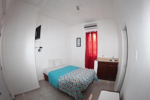 圣多明各Caribbean Hotel Santo Domingo的一间卧室配有床和红色窗帘