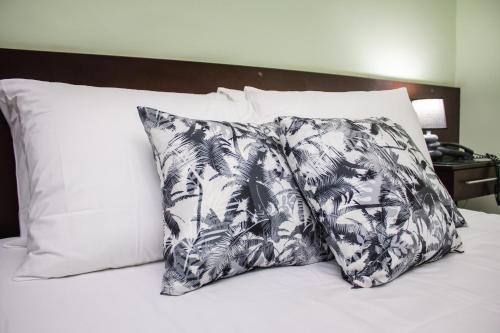 塞蒂拉瓜斯Riviera Palace Hotel的床上的黑白枕头