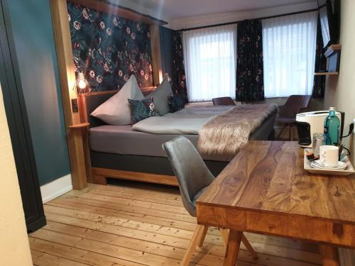 巴特索登-阿伦多夫Pelikans Krone的客房设有床、桌子、床和沙发。