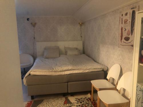 图尔库Puutaloasunto 1 km Turun Aurajoelta föriltä的一间小卧室,配有一张床和两把椅子