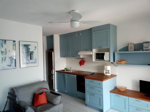 格里莫Luxury apartment in Port Grimaud的厨房配有蓝色橱柜和椅子