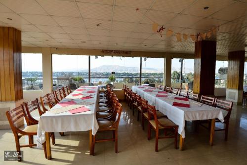 卢克索苏珊娜卢克索酒店的大型客房设有长桌子、椅子和窗户。
