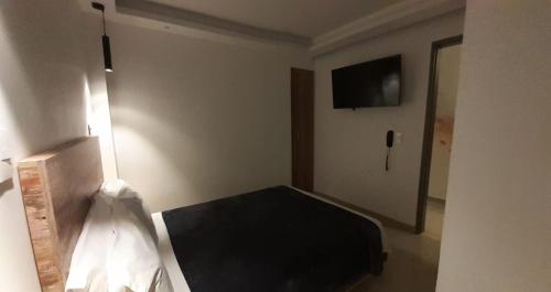 圣罗莎德卡瓦尔CIELITO LINDO的卧室配有一张床,墙上配有电视