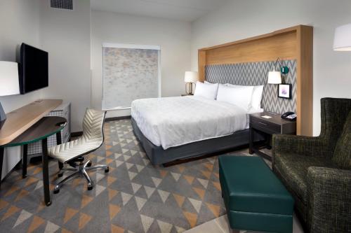 ArdenHoliday Inn & Suites Arden - Asheville Airport, an IHG Hotel的酒店客房配有一张床、一张书桌和一台电脑