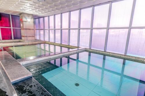 乌兰巴托蓝天大厦酒店的一座带窗户的建筑中的游泳池
