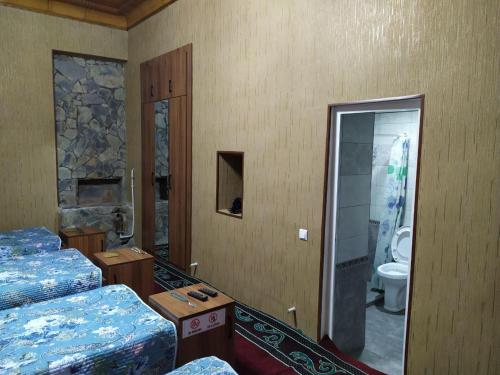 MargilanUvaysiy family guest house的客房设有两张床和一间带卫生间的浴室。
