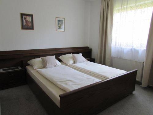 盖布利茨Gästehaus Barbara的卧室配有一张带白色床单的大床和窗户。