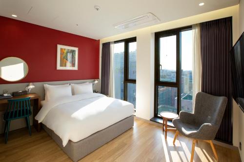 水原市阿尔特酒店的卧室配有白色的床和红色的墙壁