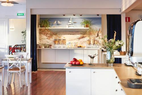 法尔肯贝里北海酒店的厨房配有白色橱柜和水果桌