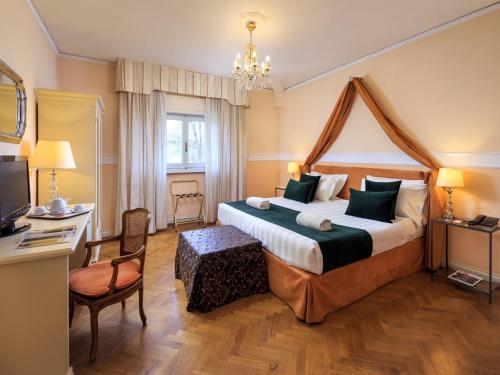 佛罗伦萨卡尔罗塔别墅酒店的酒店客房设有一张大床和一张书桌。