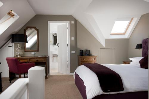奇切斯特Crouchers Hotel的一间卧室配有一张床、一张书桌和一面镜子
