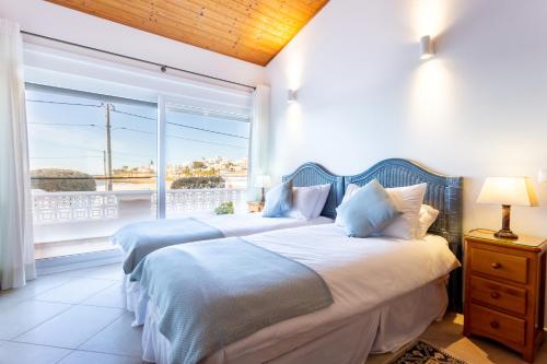 卢斯Casa Bom Porto的一间卧室设有两张床和大窗户