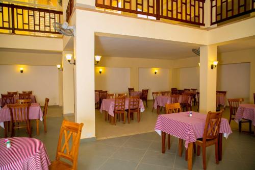 班珠尔Tropic Garden Hotel的餐厅配有桌椅和粉红色的桌布