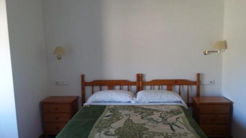 Alcolejacasa malferit的一间卧室配有一张带两个床头柜和床罩的床。