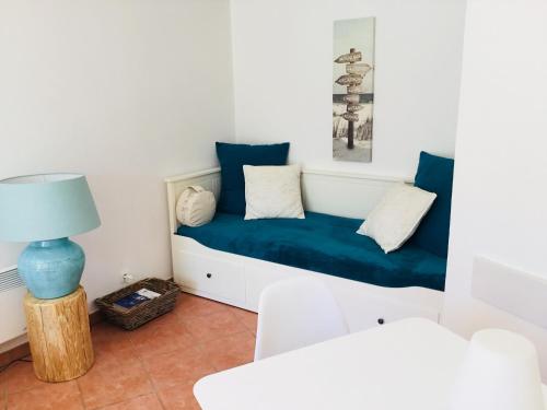 拉卡诺Lumineux, vue piscine, face au Golf, Lacanau Ocean的客厅配有带蓝色靠垫的沙发