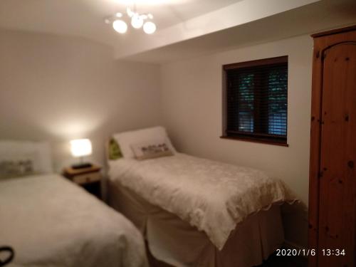 新米尔顿Glen Lodges的一间卧室设有两张床和窗户。