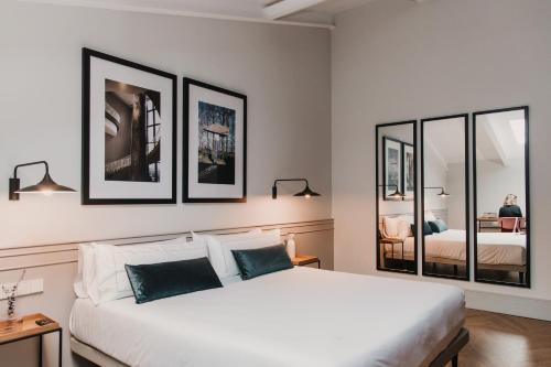 瓦伦西亚Helen Berger Boutique Hotel的一间卧室配有一张白色大床和三面镜框