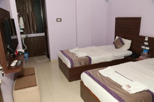 那格浦尔Hotel Sai Guest House的酒店客房设有两张床和盥洗盆