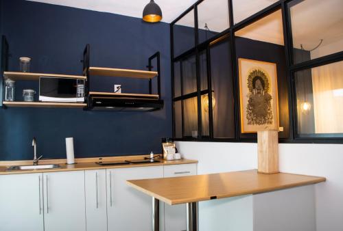 莫雷利亚Hotel Romance Morelia的厨房设有蓝色的墙壁和木制台面