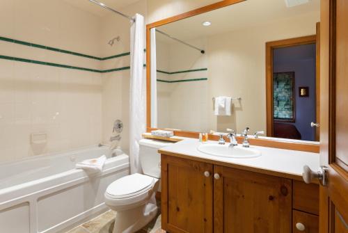 惠斯勒Treeline Townhome by Whistler Premier的浴室配有卫生间、浴缸和水槽。