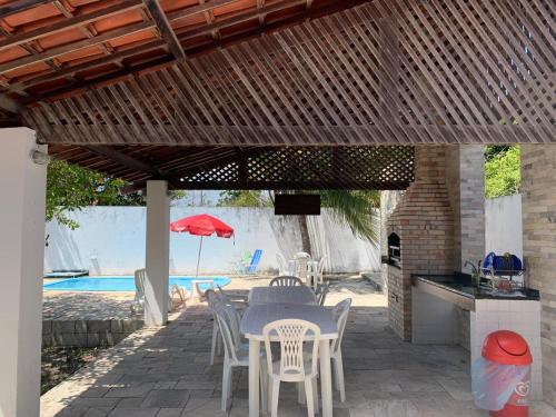 雅克南Casa de praia em Carapibus的庭院配有桌椅和遮阳伞。