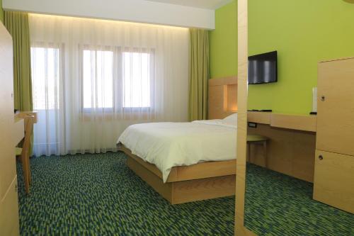 普里什蒂纳普里什蒂纳Spa国际酒店的酒店客房,配有床和电视