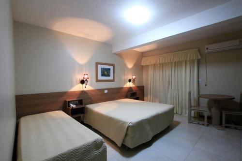 托雷斯科斯塔道皮尔兹酒店的一间卧室配有一张床、一张桌子和一张书桌
