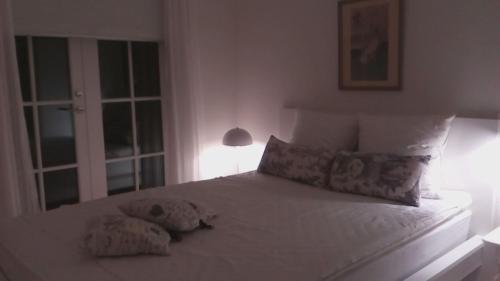 罗斯基勒Hos Anna的卧室配有白色的床和2个枕头