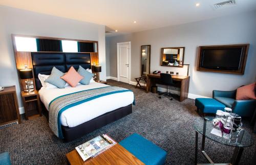利兹皇冠假日利兹酒店的酒店客房设有一张大床和一张书桌。