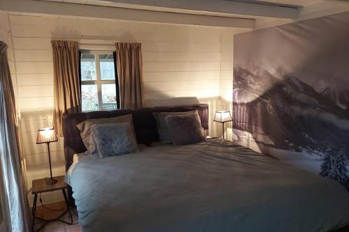 GeesterenNatuurhuis de LandJonker的卧室配有一张大床,墙上挂有绘画作品